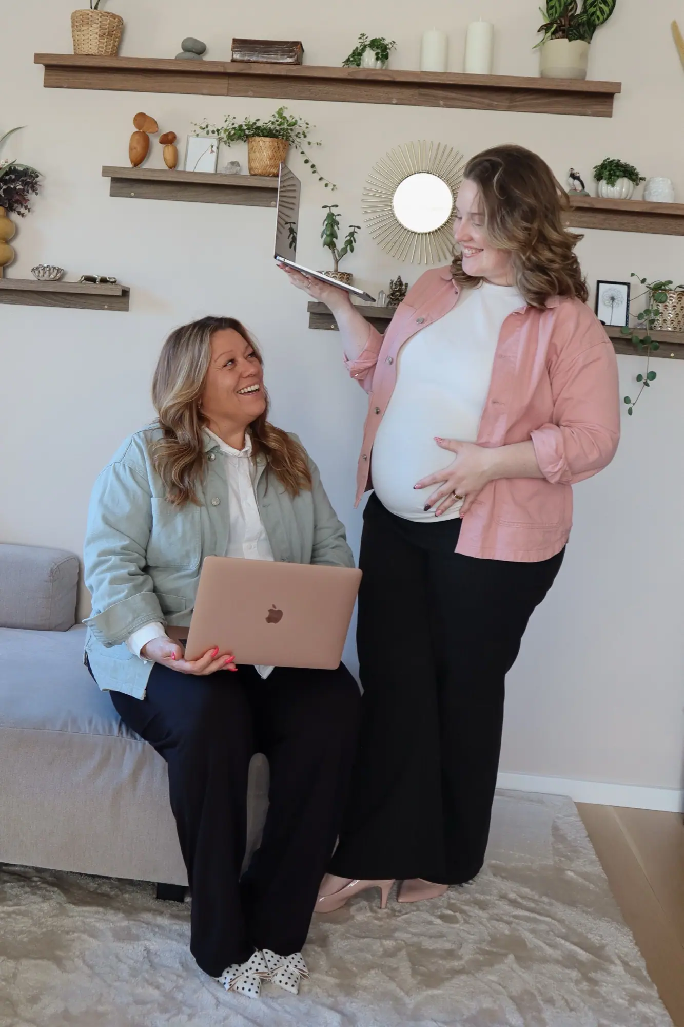 Laila sidder med en laptop og kigger op på Amalie